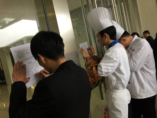 2 志愿者趴在商场的玻璃上登记信息